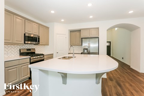 A kitchen with a white counter top and wooden cabinets.