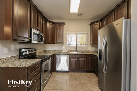 A kitchen with brown cabinets and a stainless steel refrigerator.