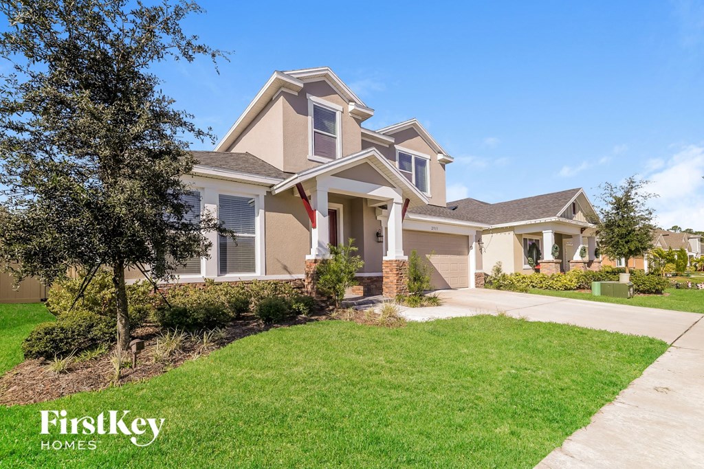 a house with a lawn and a sidewalk in front of it