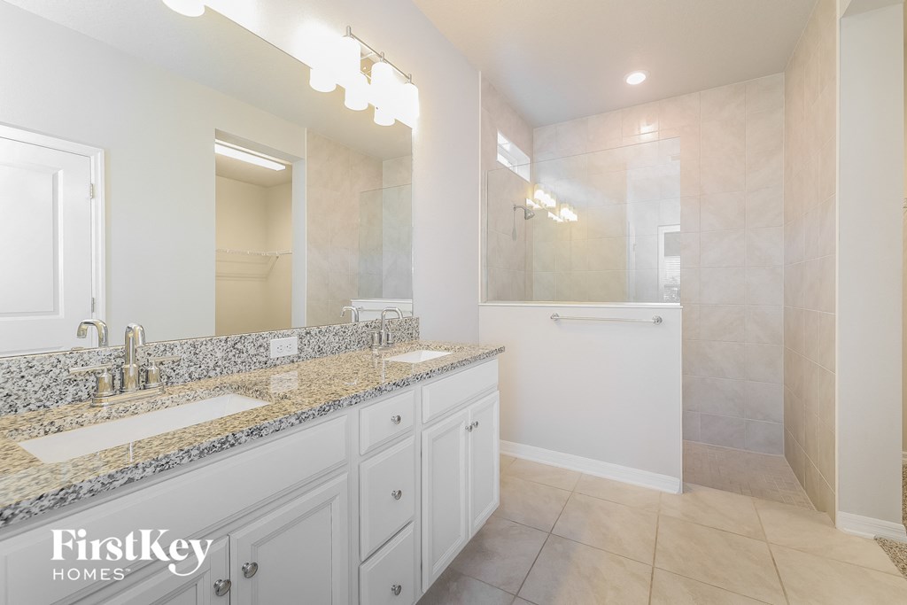 a white bathroom with two sinks and a shower
