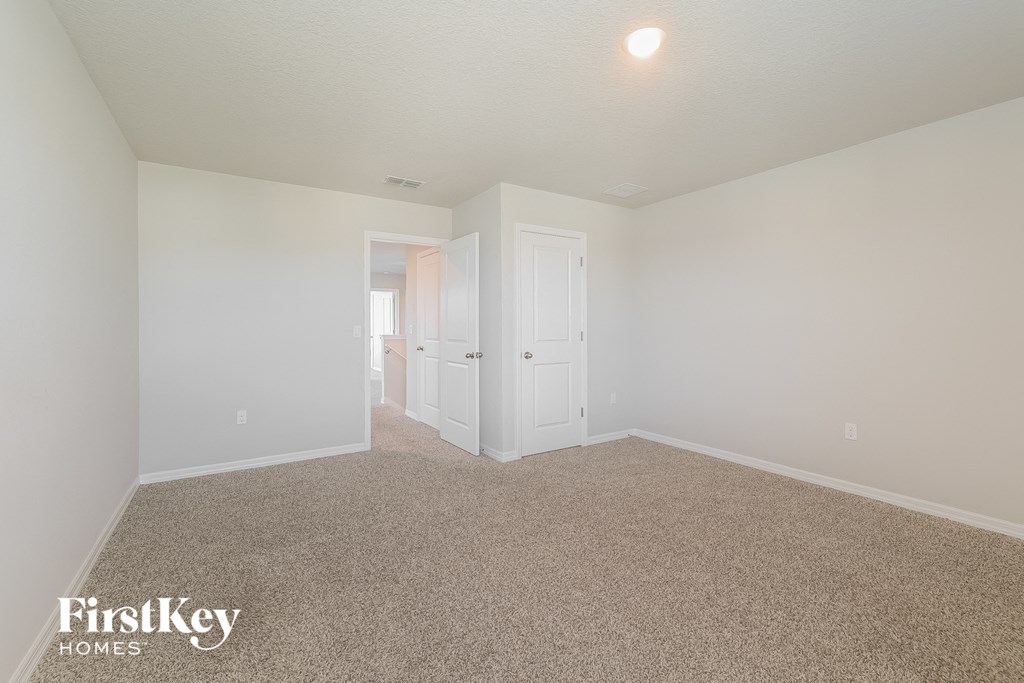 a spacious living room with carpet and white walls