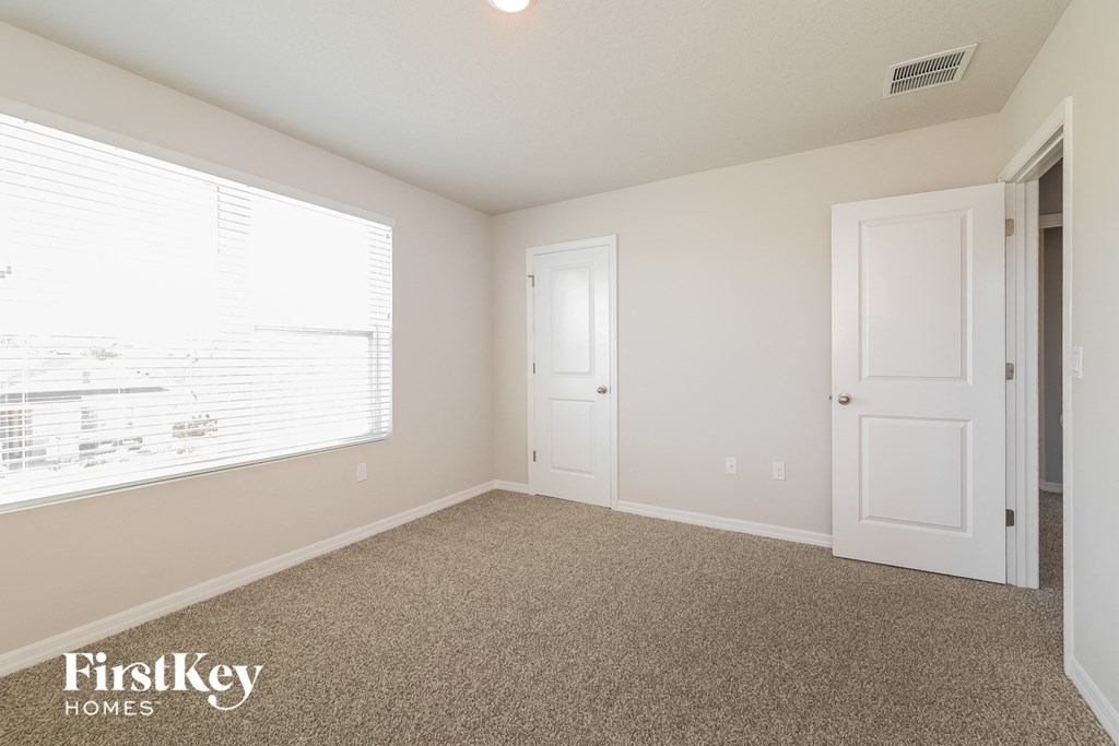 a bedroom with a large window and a white door