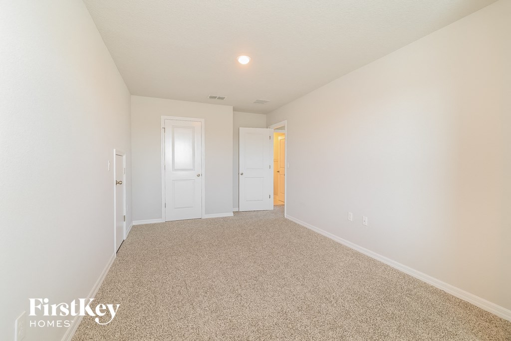a spacious living room with carpet and white walls