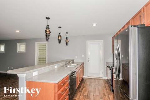 A kitchen with a white counter top and wooden floors.