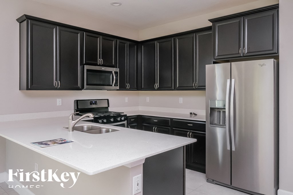 a kitchen with black cabinets and a white counter top