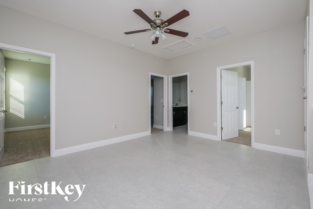 a large empty living room with a ceiling fan