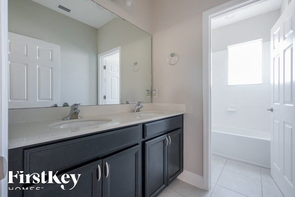 a bathroom with two sinks and a large mirror