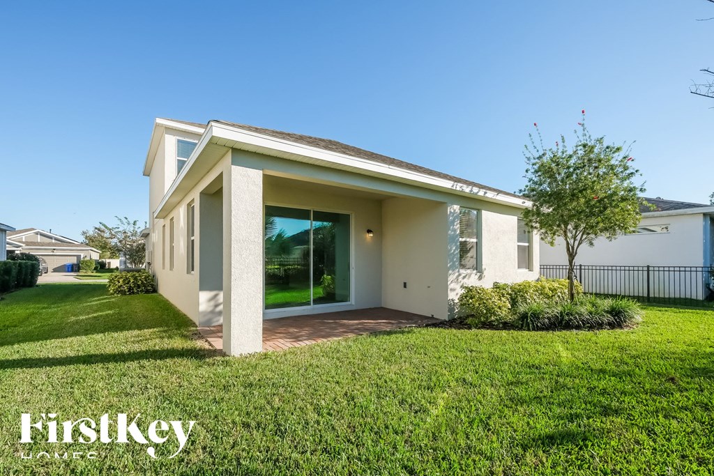 a small white house with a lawn and grass