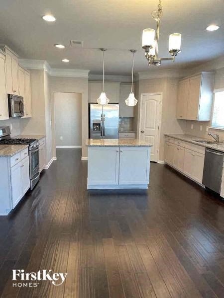 a large kitchen with white cabinets and wood floors