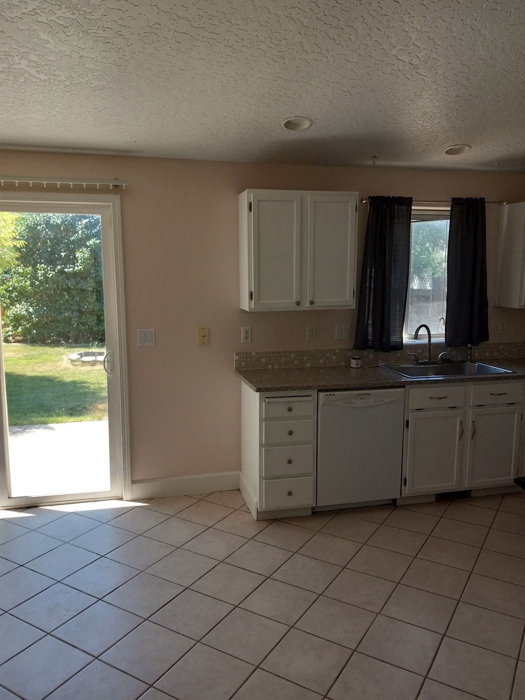 an empty kitchen with a door to the backyard