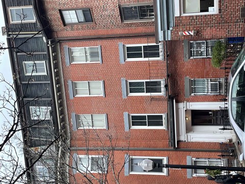 A tall red brick building with many windows.