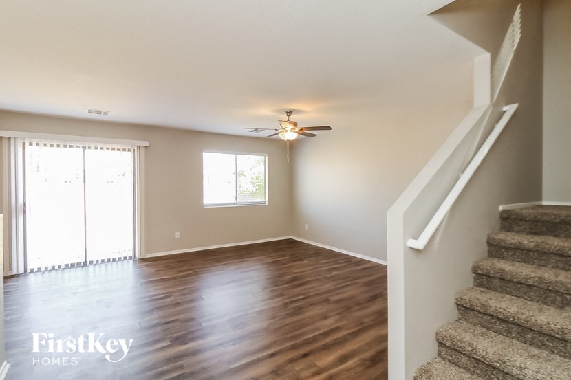 a living room with a staircase and a ceiling fan
