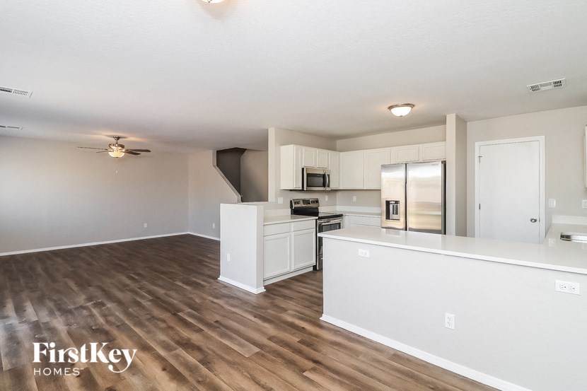an open kitchen and living room with a wood floor