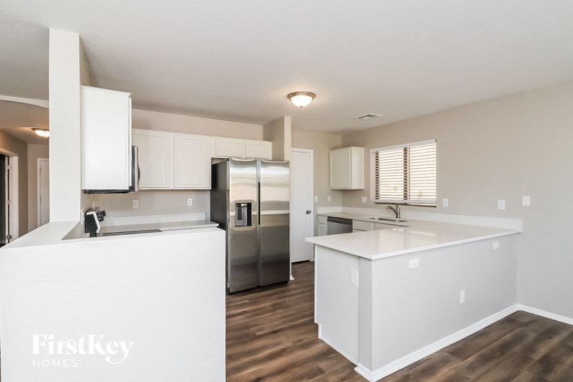 a kitchen with white cabinets and a stainless steel refrigerator