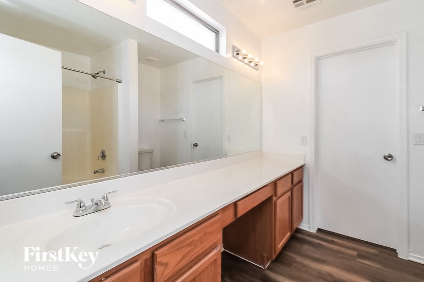 a bathroom with a white sink and a large mirror