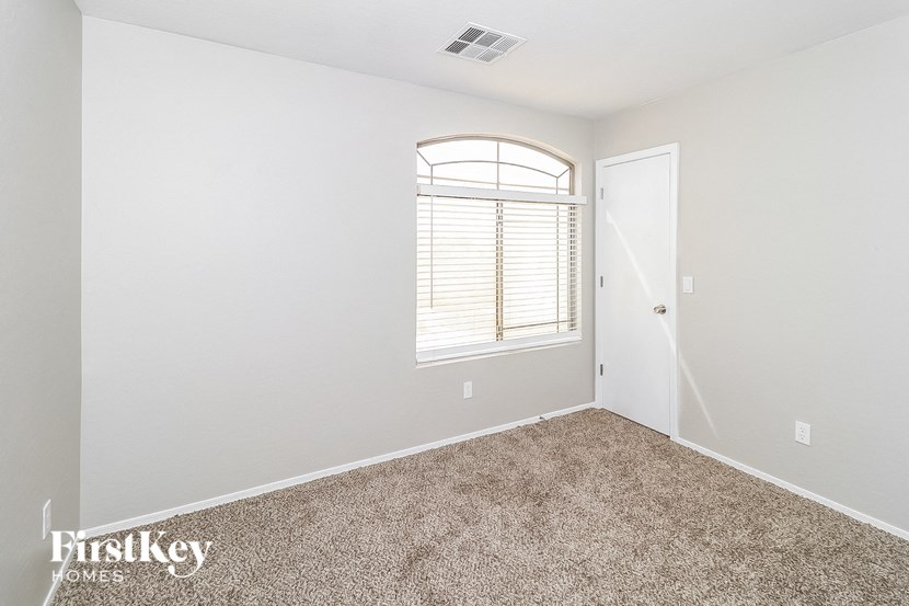 an empty room with carpet and a window