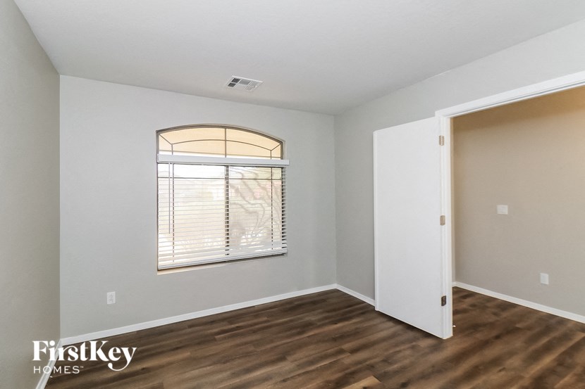 the living room of an empty house with wood flooring and a window