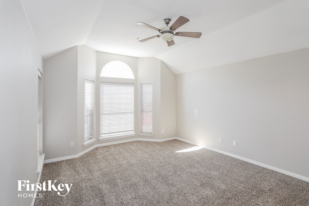 an empty room with a ceiling fan and a window