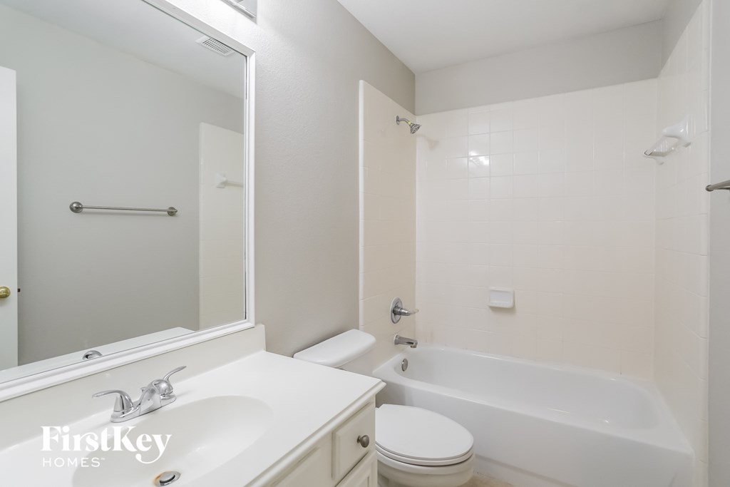 a bathroom with a sink toilet and tub and a mirror