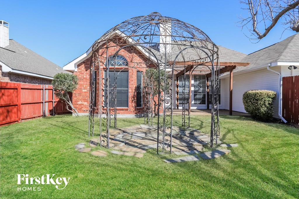 a gazebo in a yard in front of a house