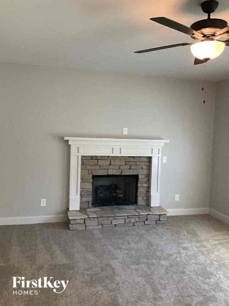 a living room with a fireplace and a ceiling fan
