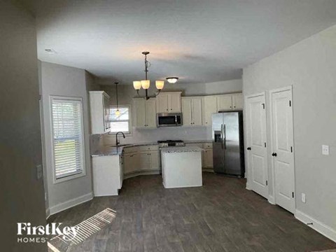 a large kitchen with white cabinets and a refrigerator