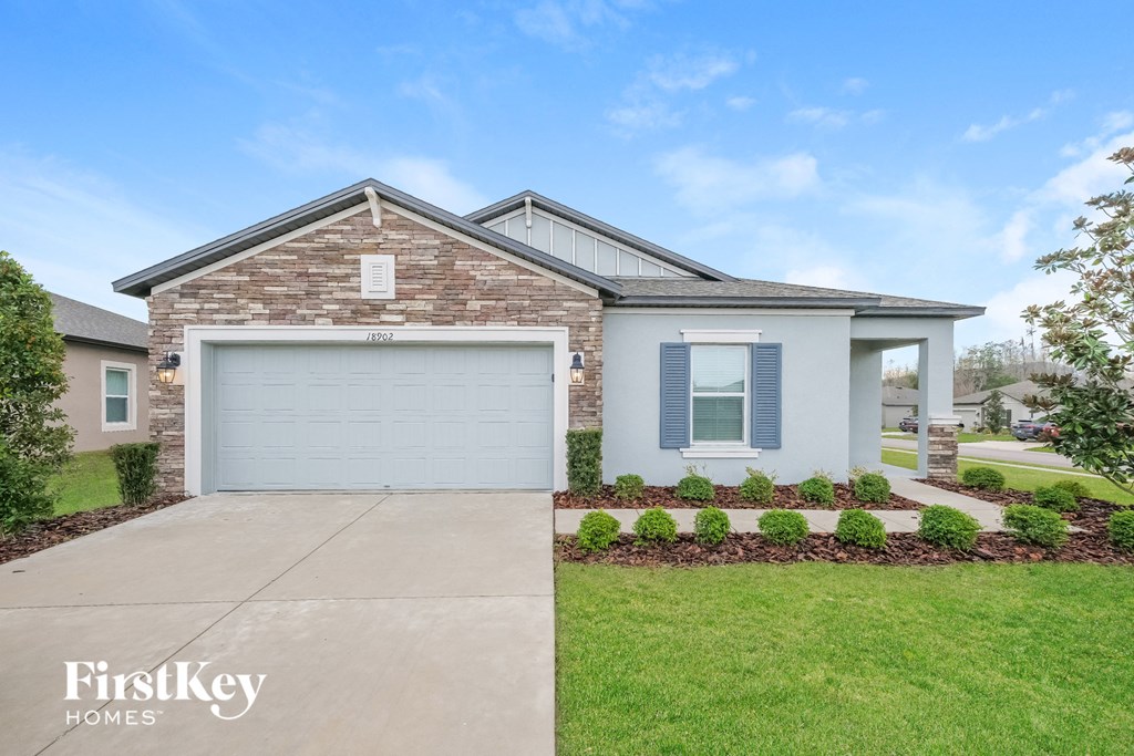 A house with a garage and a driveway in front of it.