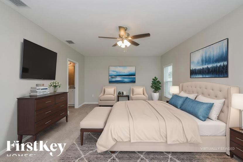 A bedroom with a large bed and a ceiling fan.