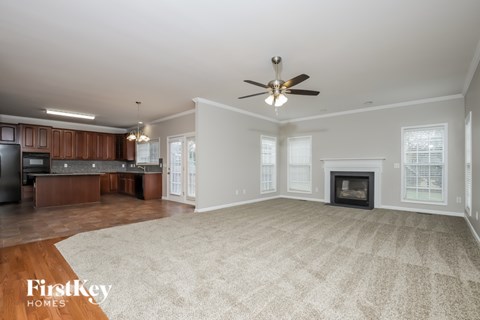 A spacious living room with a fireplace and a television.