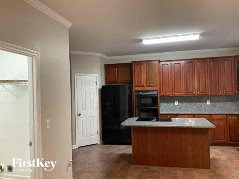 a kitchen with an island and a black refrigerator