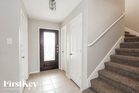 A staircase with a carpeted runner and a white door on the right.
