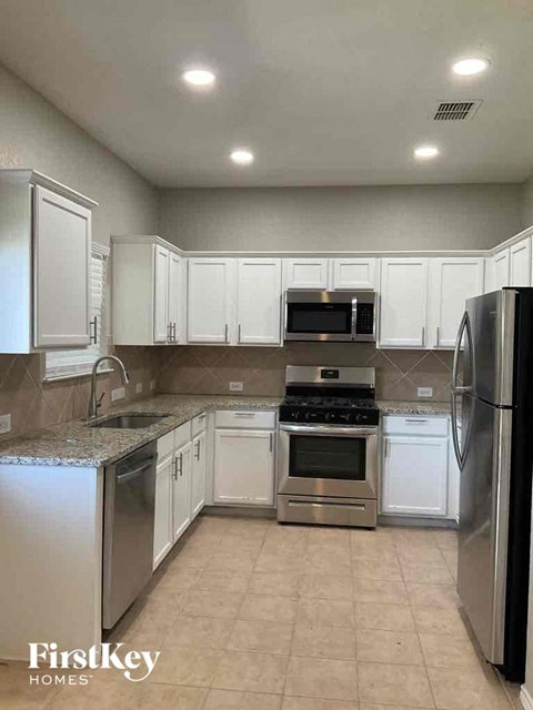 A kitchen with white cabinets and stainless steel appliances.