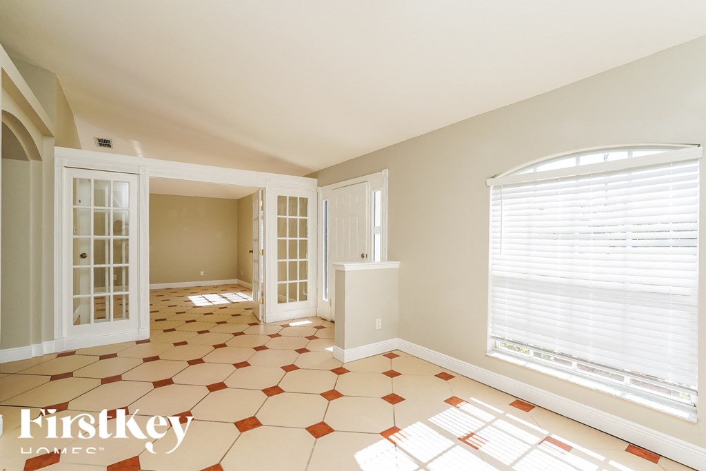 a dining room with a large window and a tiled floor