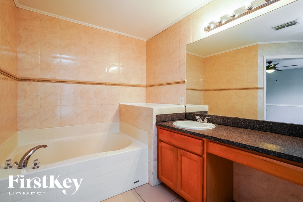 a bathroom with a tub and a sink and a mirror