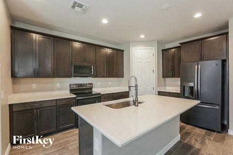 a kitchen with a large white counter top and black appliances
