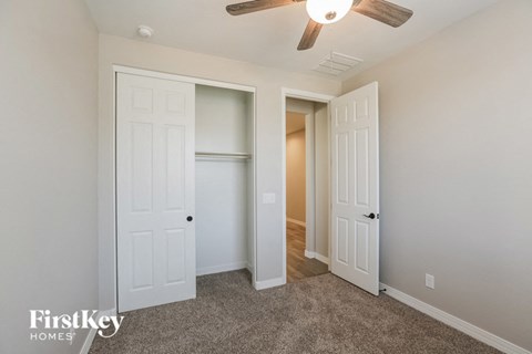 a bedroom with two closets and a ceiling fan