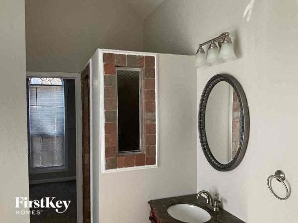 a bathroom with a sink and a mirror and a window