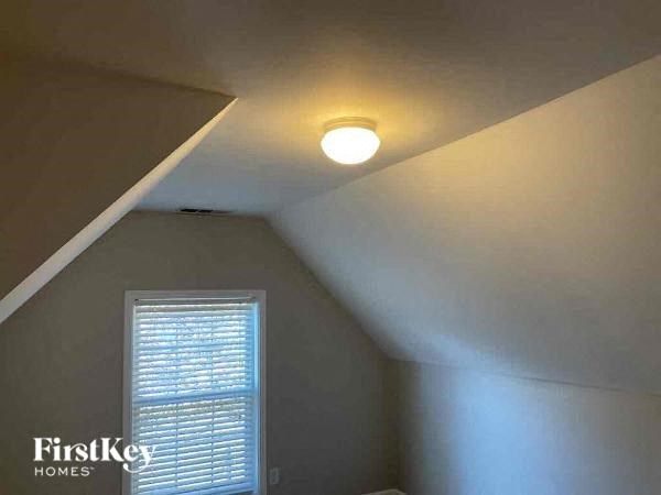 a bedroom with a ceiling light and a window