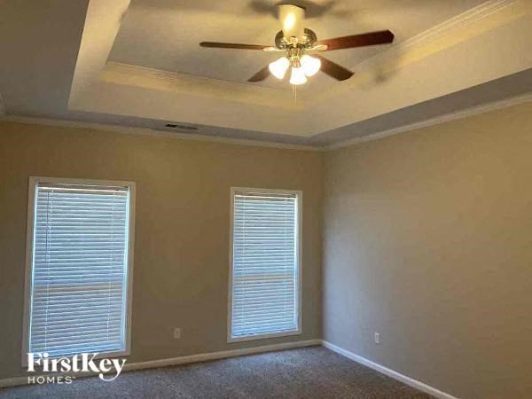 an empty bedroom with a ceiling fan and a window