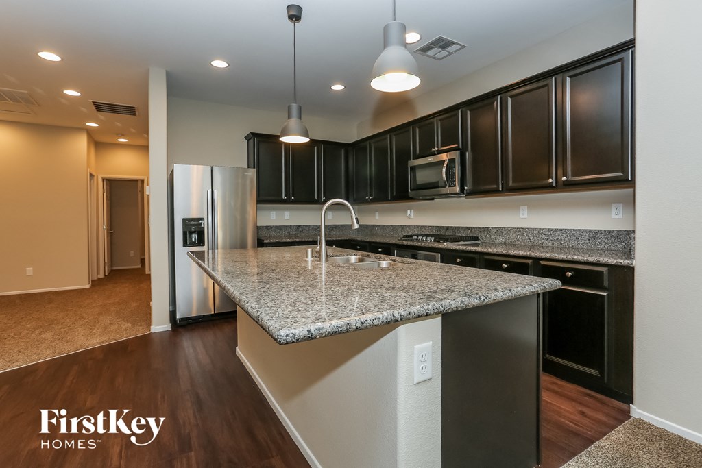 A kitchen with granite countertops and stainless steel appliances.