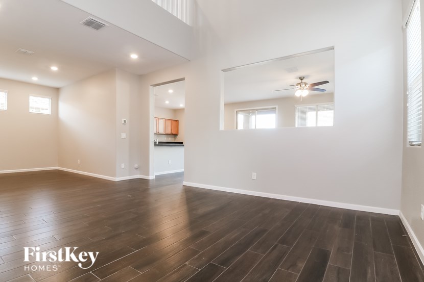 A spacious room with wooden floors and a mirror on the wall.