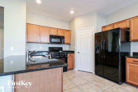 A kitchen with wooden cabinets and black appliances.