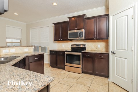 A kitchen with brown cabinets and appliances.