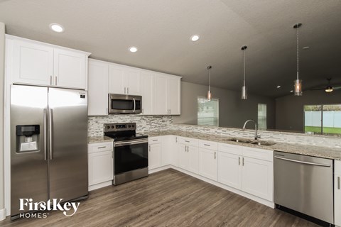 A modern kitchen with stainless steel appliances and white cabinets.