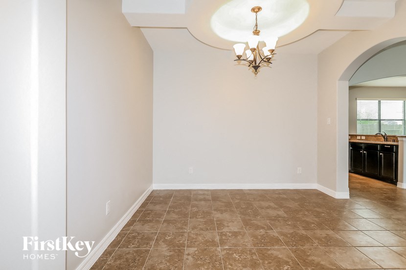 a dining room with a large window and a chandelier