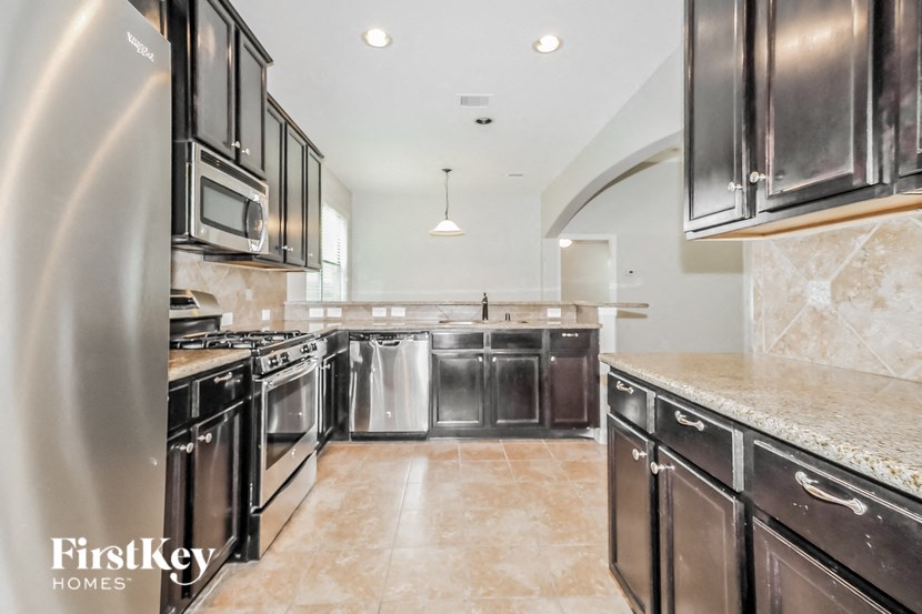 a large kitchen with stainless steel appliances and marble counter tops