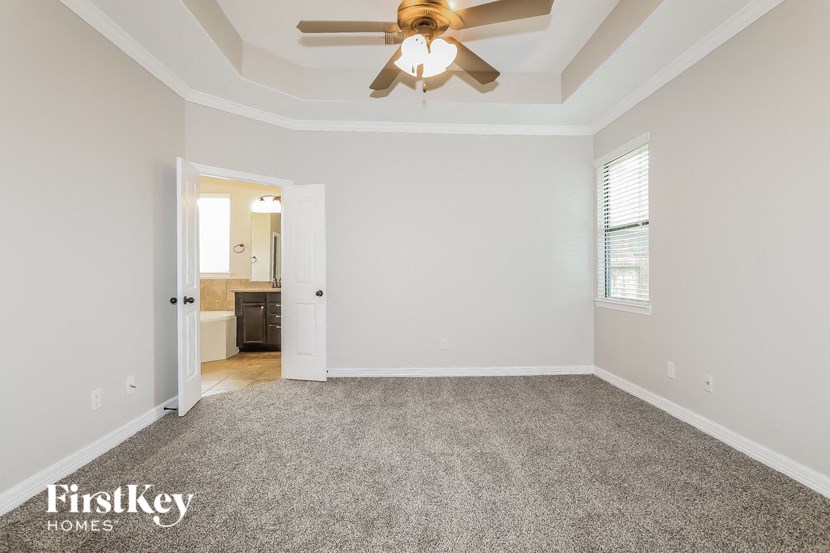 the living room of an empty house with a ceiling fan