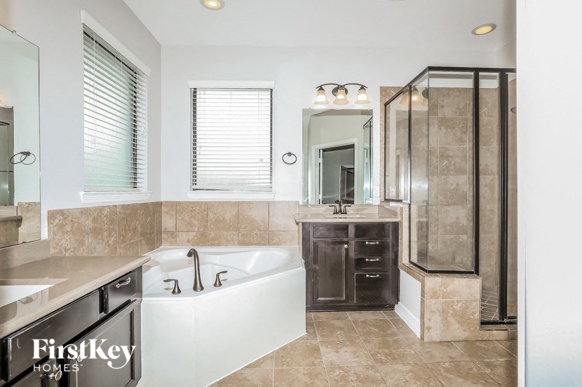 a bathroom with a tub and a shower and a sink
