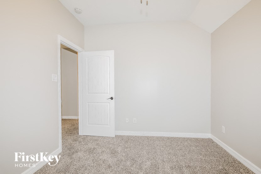 a bedroom with a white door and a carpeted floor