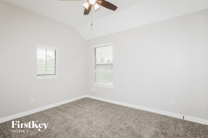 a bedroom with carpet and a ceiling fan